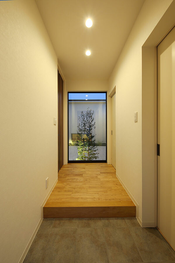 中庭を臨む明るく開放的な玄関とモダンで個性的なキッチン空間をもつ二人の家